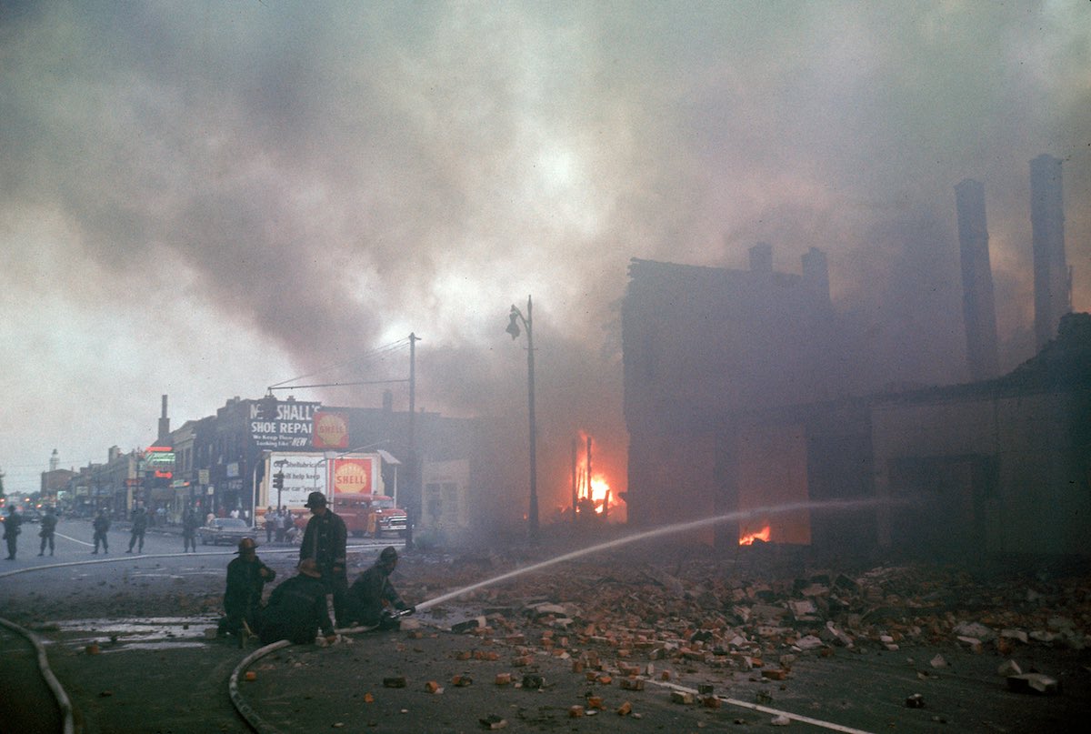 DETROIT, UNITED STATES - JULY 01:  Firemen are protected by police (from snipers, etc.) while they battle smoking blaze after race riots rock the city.  (Photo by Declan Haun/The LIFE Picture Collection/Getty Images)