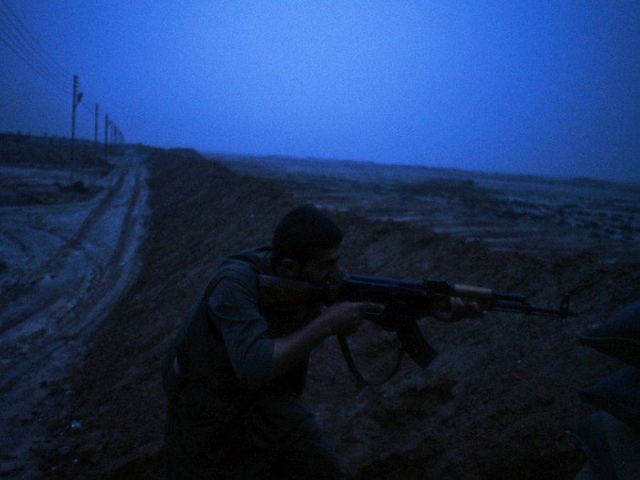 IRAQ. Dokuk. December 3, 2014. A Kurdish PKK fighter aims his rifle toward an Islamic State (IS) position during sporadic clashes in the front line near the village of Dokuk, about 35Km south to Kirkuk.