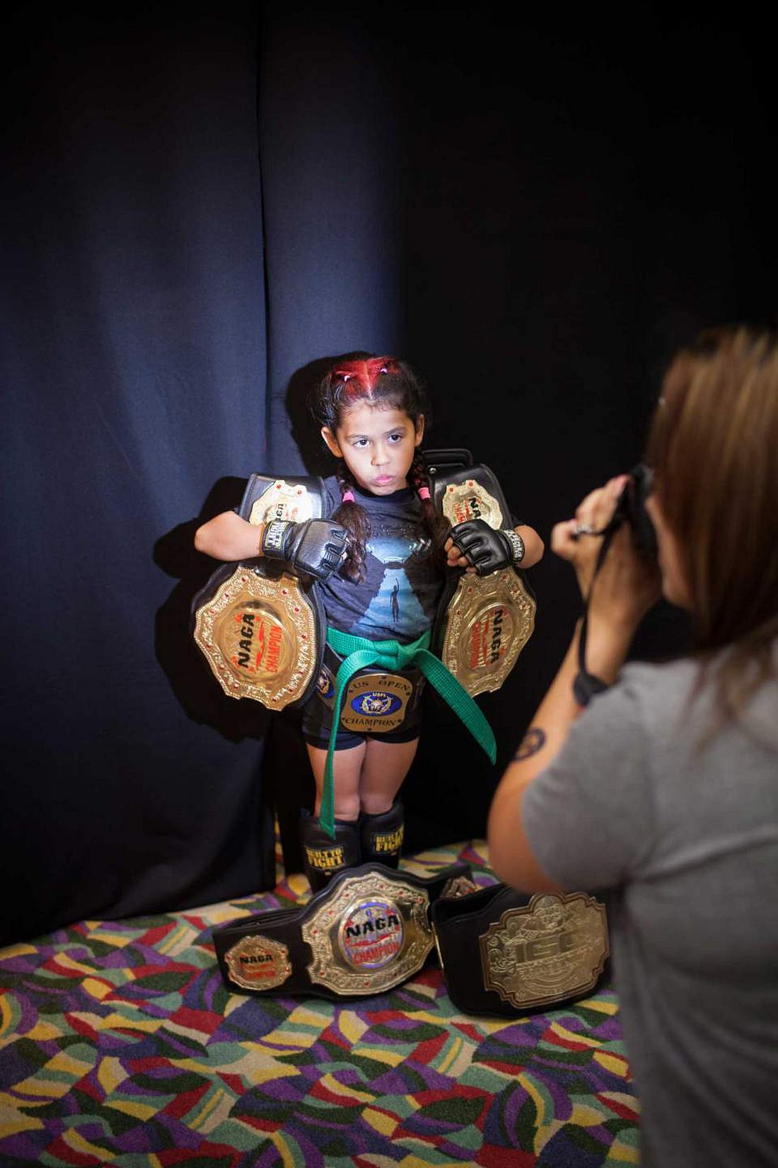 Regina "Black Widow" Awana, 7, with her Championship belts, posing for her sponsor at United States Fight League(USFL) All-star Pankration show at Blue Water Casino in Parker, Arizona on 25th of October 2013. Photo: Miikka Pirinen