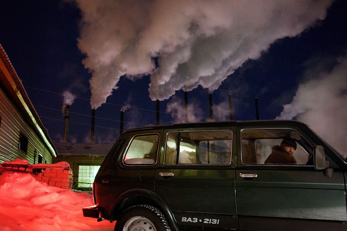 A car drives past a water-heating plant in Naryan-Mar, capital of the resource-rich Nenets Autonomous Region in Arctic Russia, where many of the oil and gas exploration companies have their local headquarters.