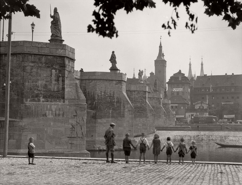 Bridge with statues seen from below, group of children holding hands, Würzburg, 1925